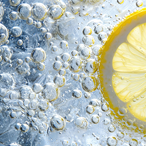 Lemon slice drop in fizzy sparkling water, juice refreshment