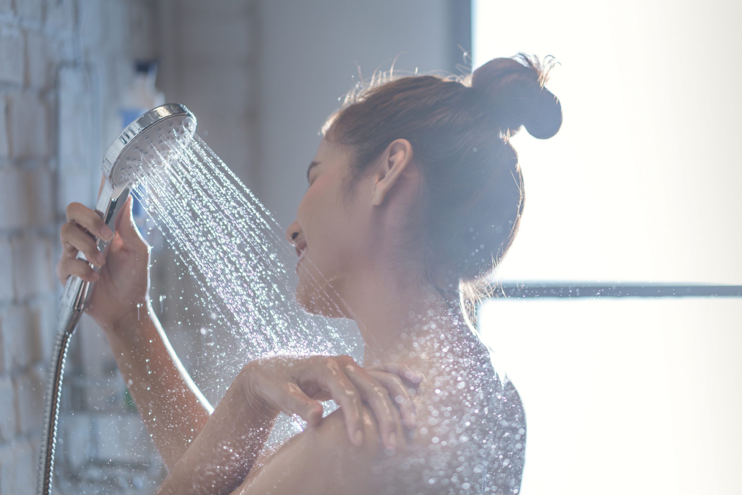 Asian woman is taking a shower and rubbing her shoulders